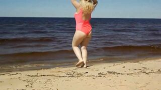 Juicy MILF in a pink swimsuit, on the beach