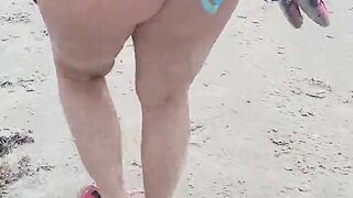 Blonde milf walking on beach in a thong